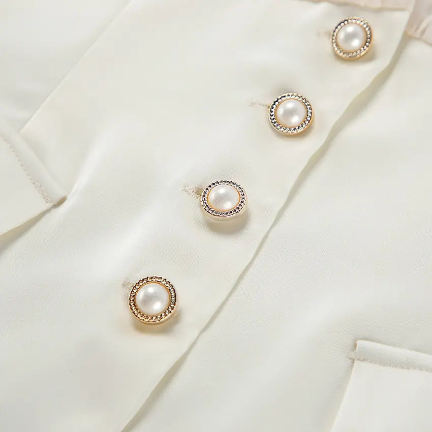 Close-up of pearl buttons with gold rims