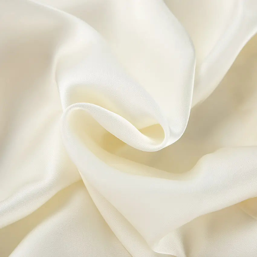 Macro close-up of cream satin fabric