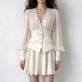 Model wearing cream chiffon bodice pearl button waist mini dress, front view