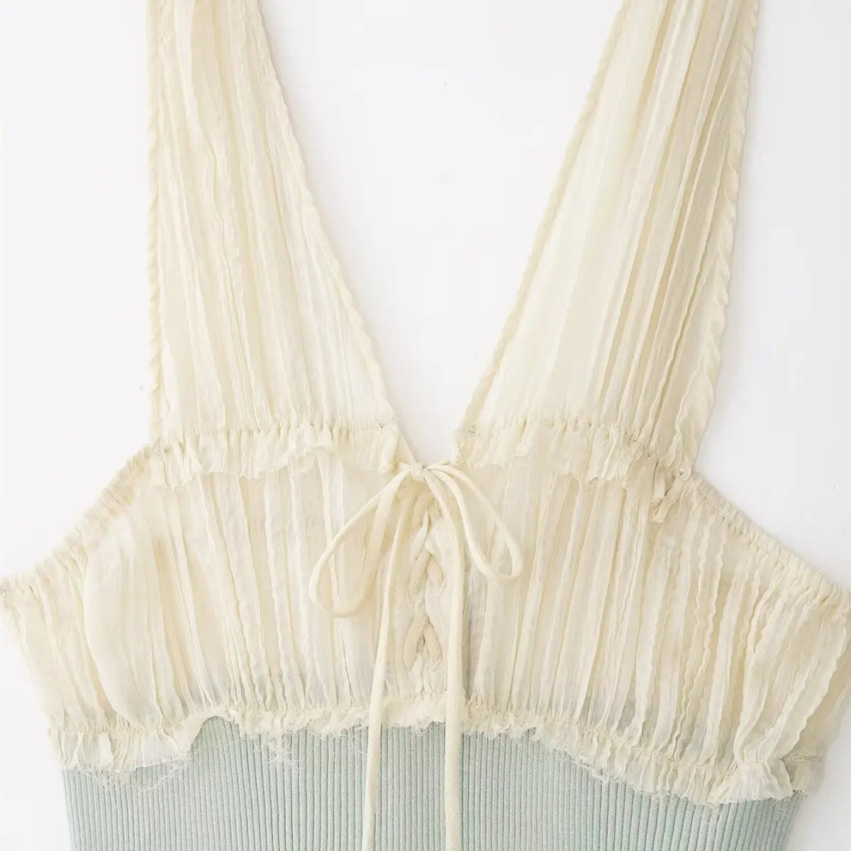 Front view of cream chiffon and mint ribbed knit cami top, showing the lace-up detail, ruffled chiffon straps, and contrast knit body