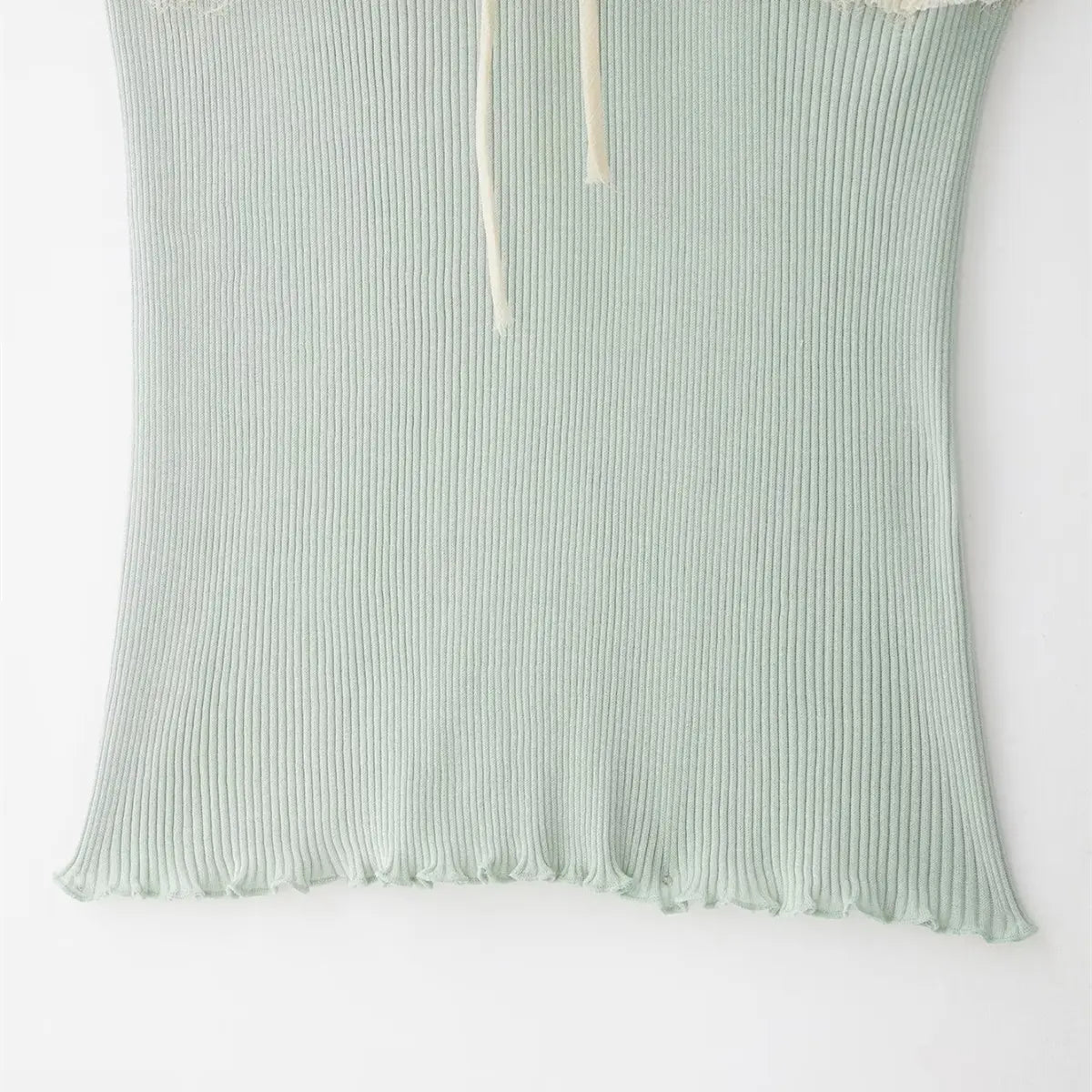 Hem detail of the mint ribbed knit cami top, showing the lettuce-edge finish and fabric texture
