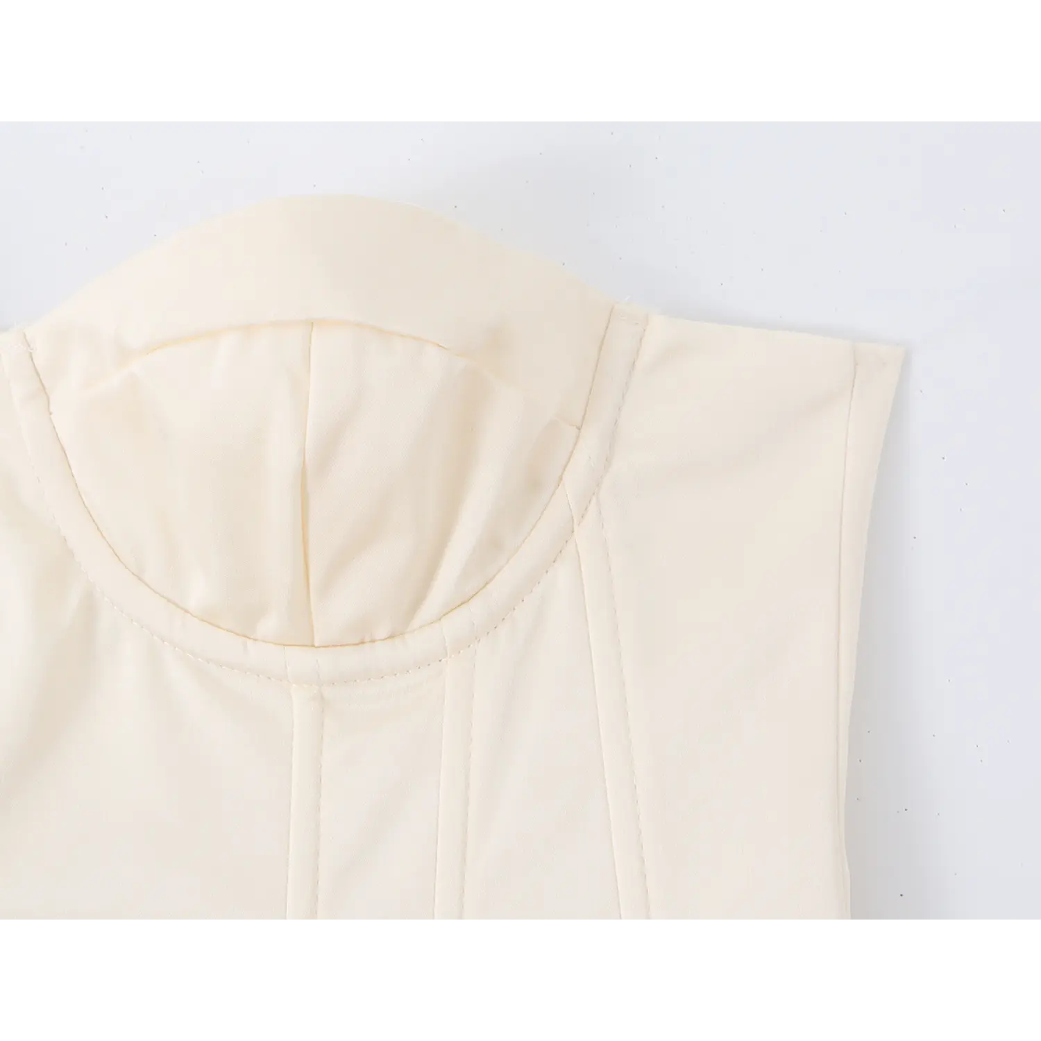 Close‑up of padded sweetheart bust cup and fine vertical stitching detail on cream corset top