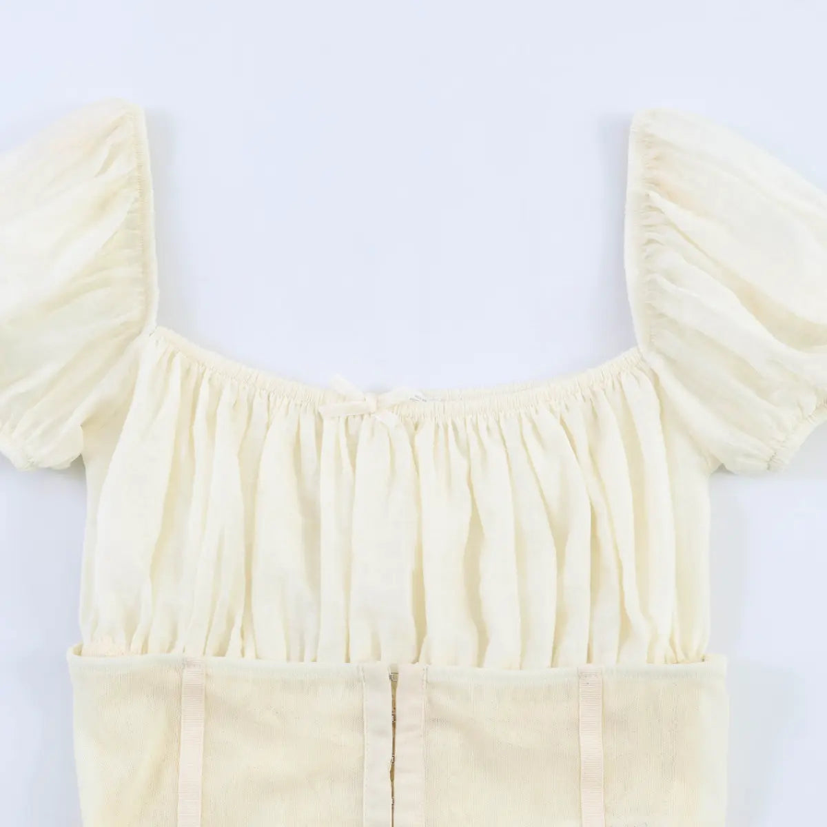  Full front view of the top, showing the square neckline, gathered bust, center bow detail, and corset-style hook-and-eye closure.