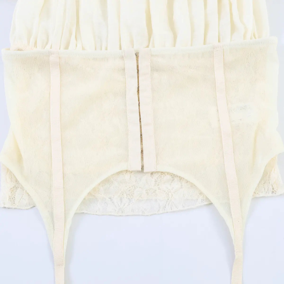 Close-up of the corset-style hook-and-eye closure, internal boning, mesh lining, and delicate lace trim at the hem.