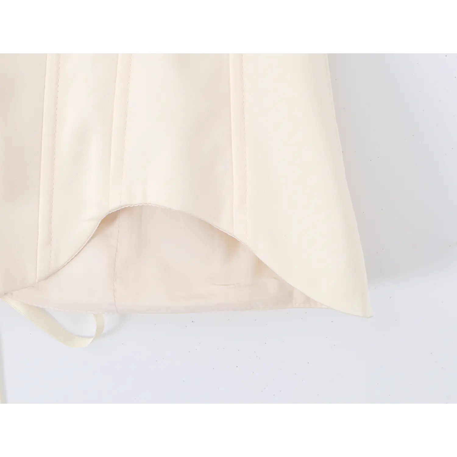 Close‑up of curved scalloped hem and inner lining of cream boned corset top