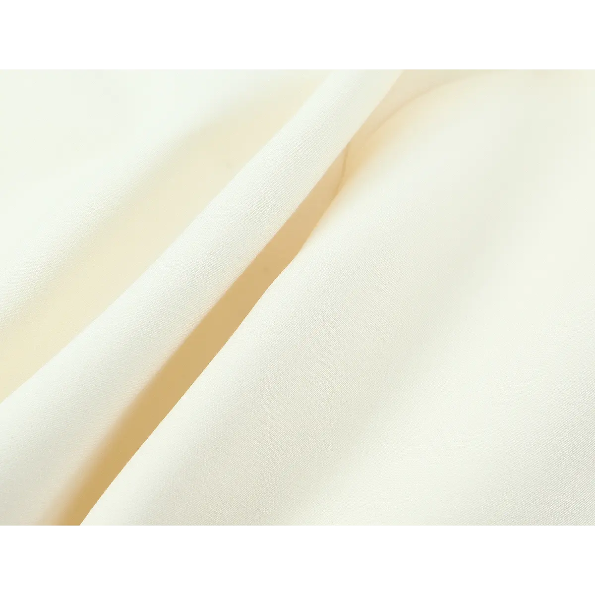 Close-up of cream crepe fabric, showing the smooth, soft texture and drape