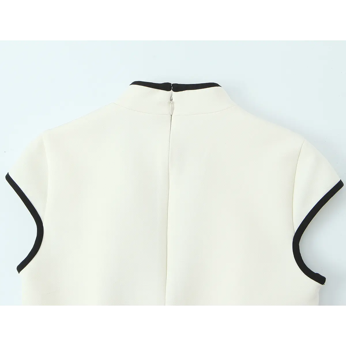 Back view of the cream crepe qipao dress, showing the center back zipper, mandarin collar, and black-trimmed cap sleeves