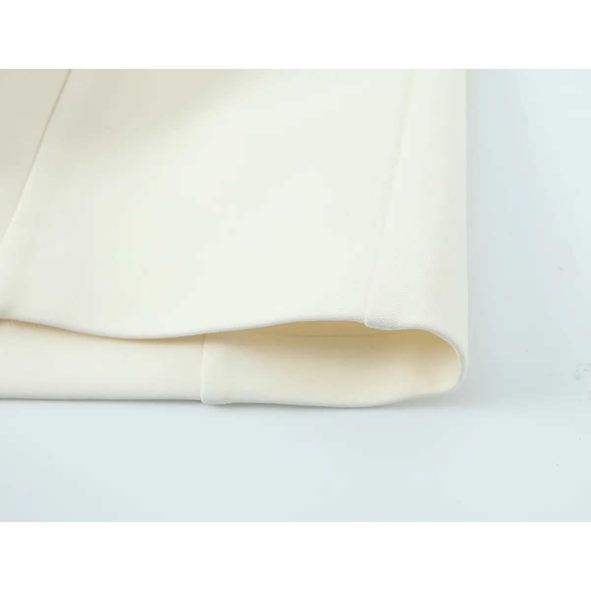 Close-up of the dress hem, showing the crepe outer fabric and inner lining