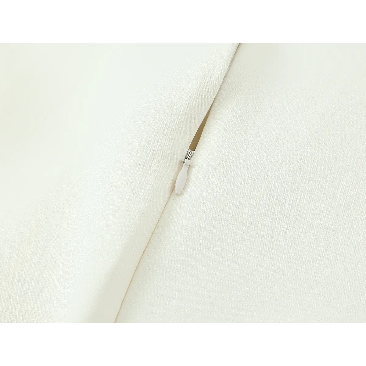 Close-up of the hidden zipper on the cream crepe qipao dress, showing the matching pull and smooth fabric