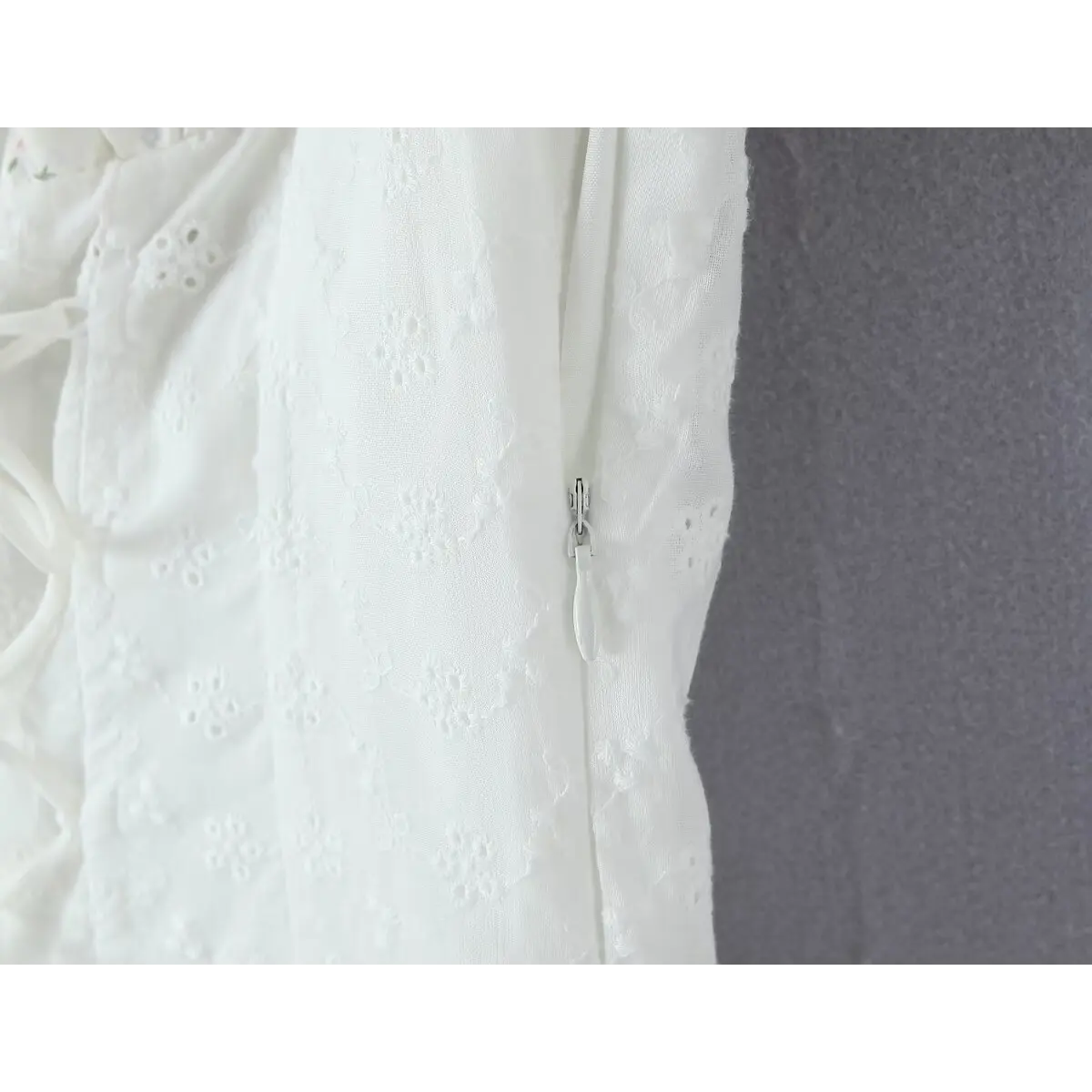  Close-up of the invisible side zipper, integrated into the eyelet-embroidered bodice.