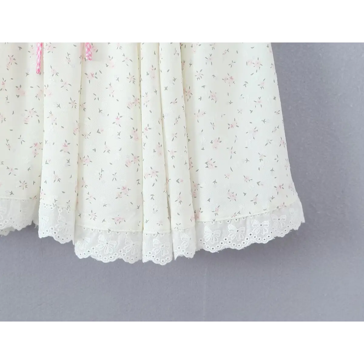 Close-up of the skirt hem, showcasing the delicate butterfly lace trim and finished stitching.