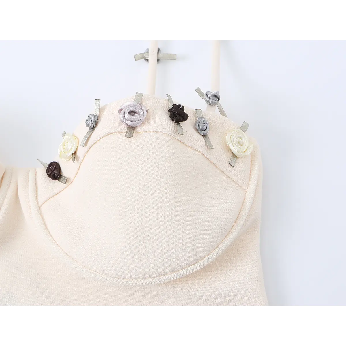 Close-up of the dress's bust area, showcasing the intricate rose appliqus on the cup and strap details.