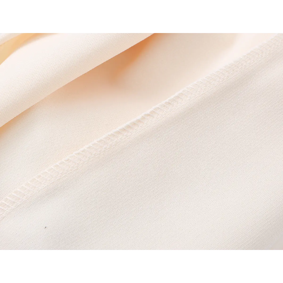 Close-up of the dress's seam, highlighting the precise, clean stitching and fabric construction.