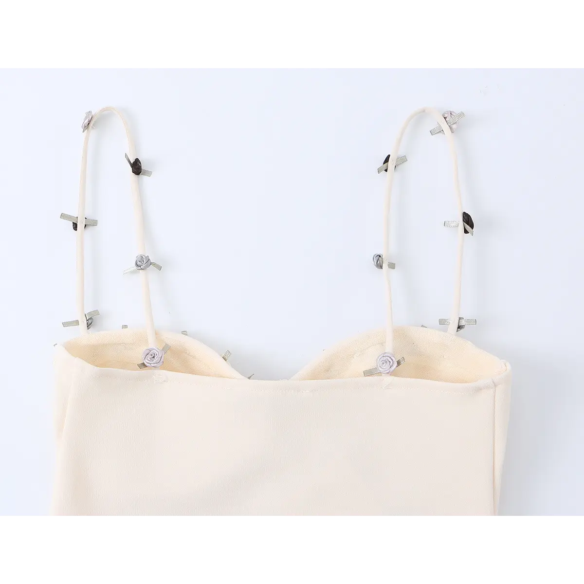 Back view of the dress's straps, showing the arrangement of rose appliqus on the cream fabric.