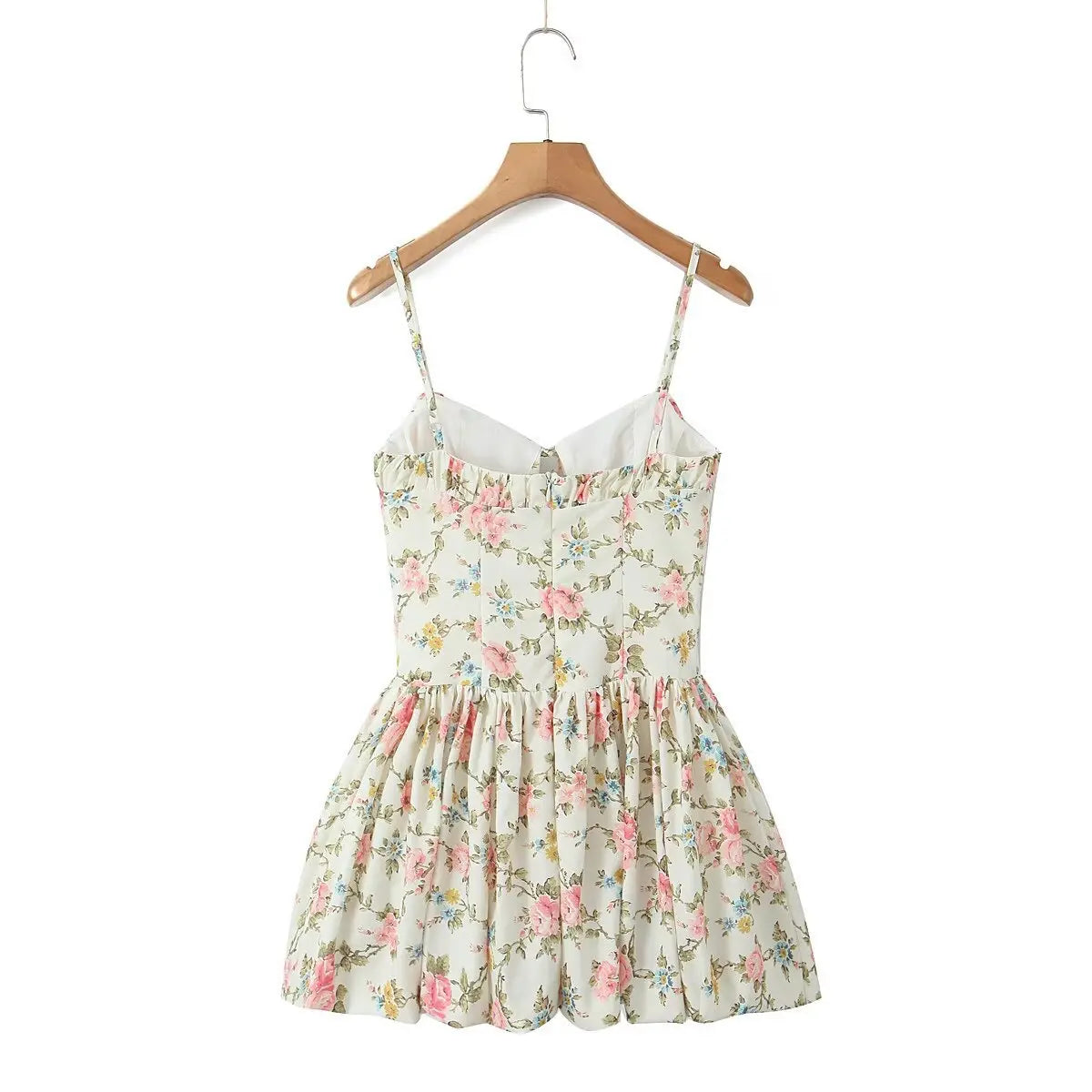 Back view of the cream floral cami dress on a wooden hanger, showing silhouette and print.