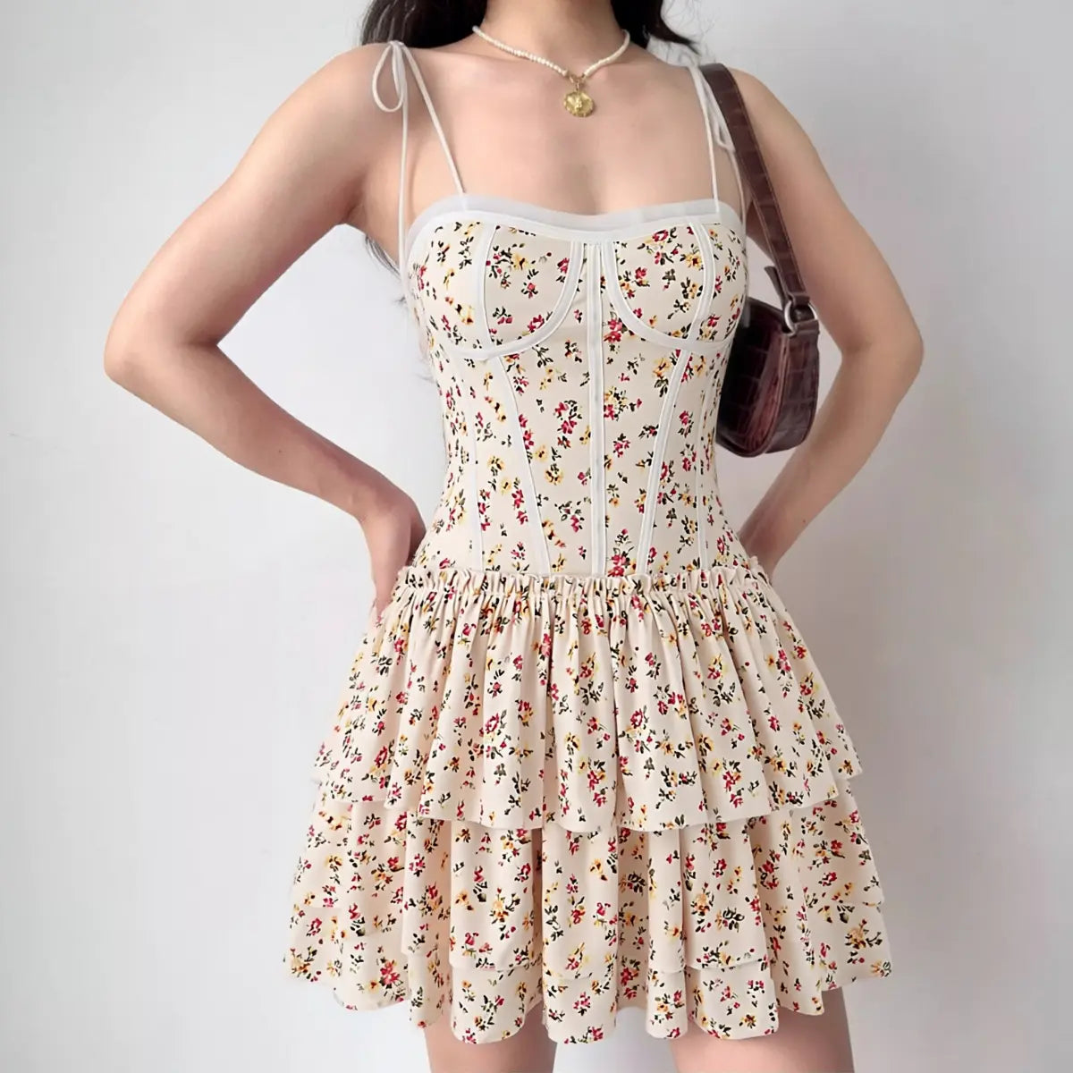 Woman wearing cream floral print cami tiered mini dress, full front view