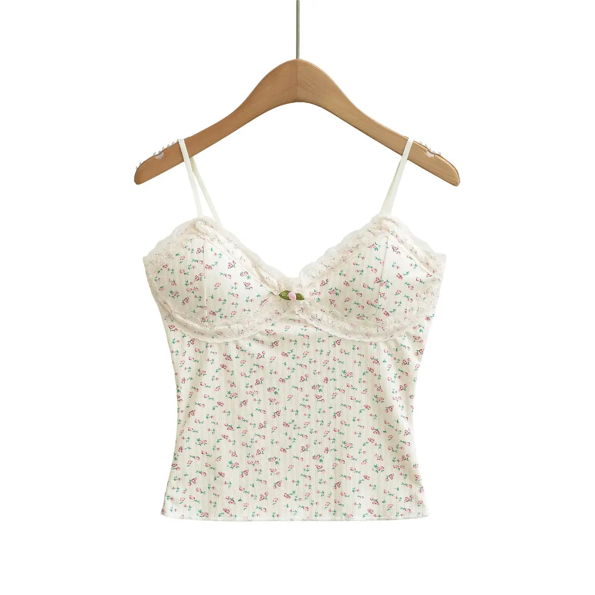 Studio shot of a cream floral cami top, featuring lace trim, a fabric rose accent, and adjustable straps.