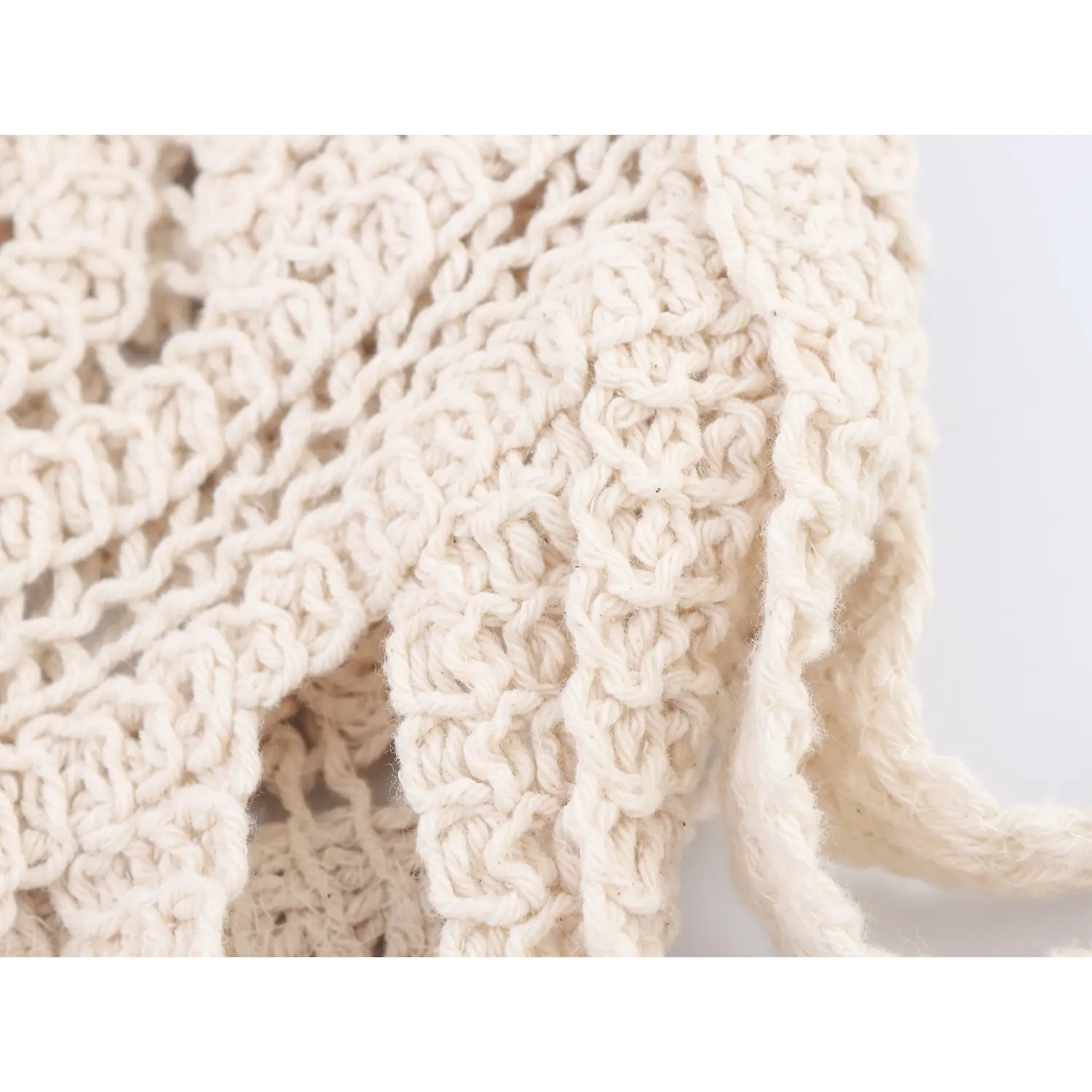 Macro close-up of openwork floral crochet texture of cream boho midi skirt
