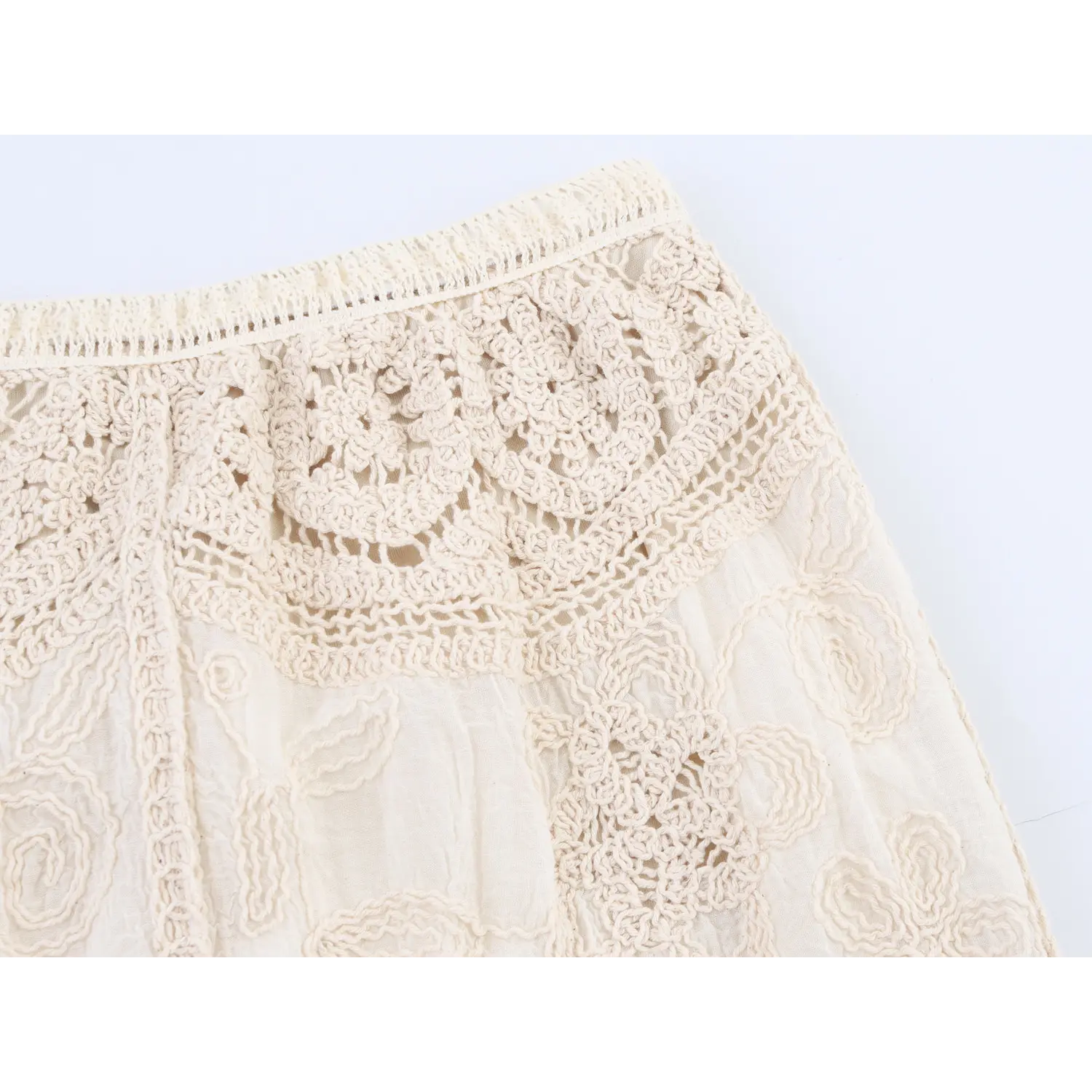 Partial shot isolated white background, waist floral crochet detail of cream tassel midi skirt