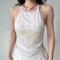 Model lifestyle shot wearing cream vintage floral embroidered halter neck pointed hem crop top