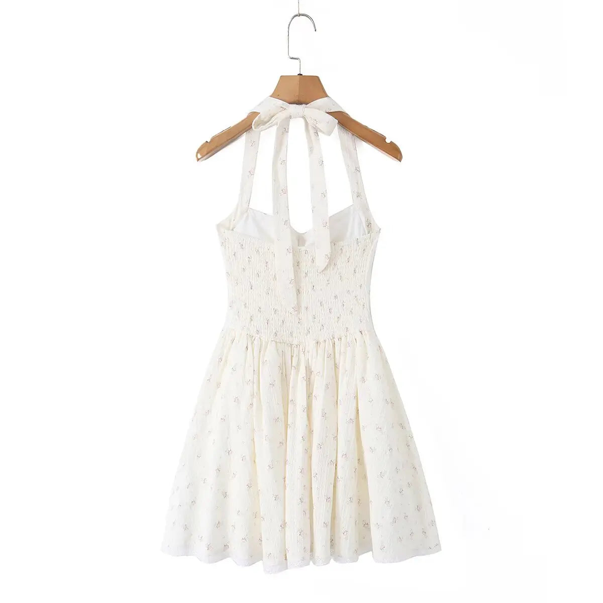 Cream floral print halter mini dress hanging on wooden hanger, full back view