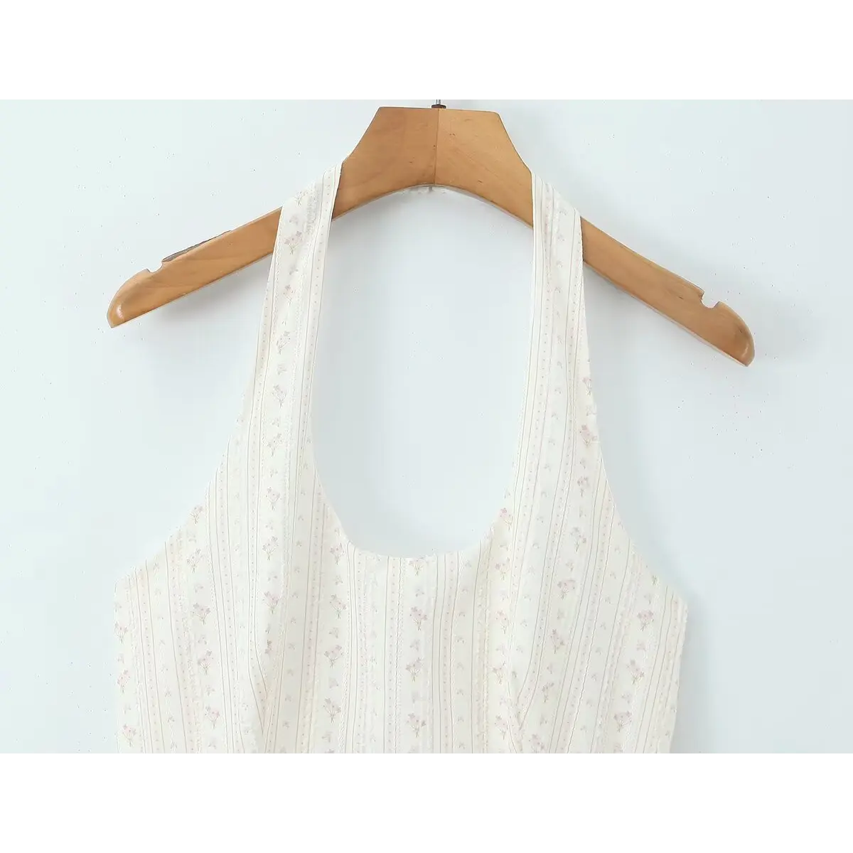 Close-up of the halter neckline and corset-style bodice on the cream floral dress
