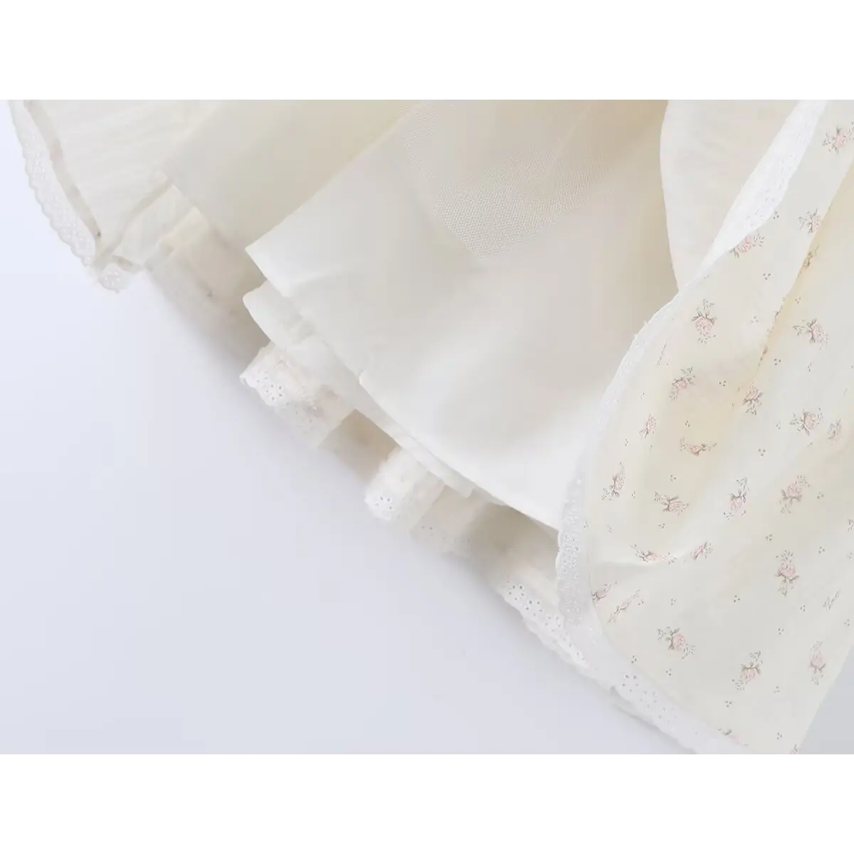 Close-up of the flared skirt hem and inner lining on the cream floral halter dress