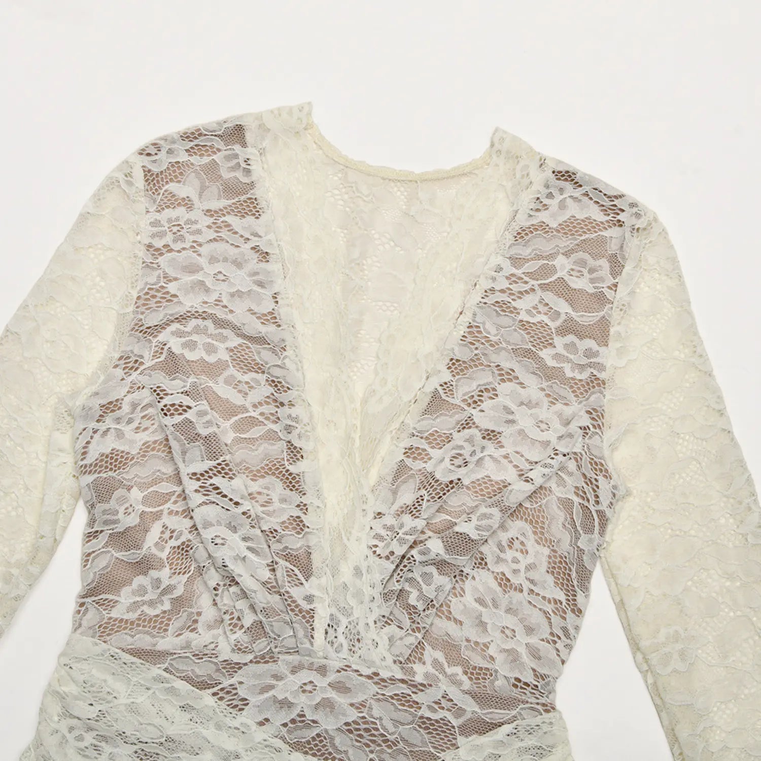 Flat lay closeup cream floral sheer lace deep v neckline fabric detail