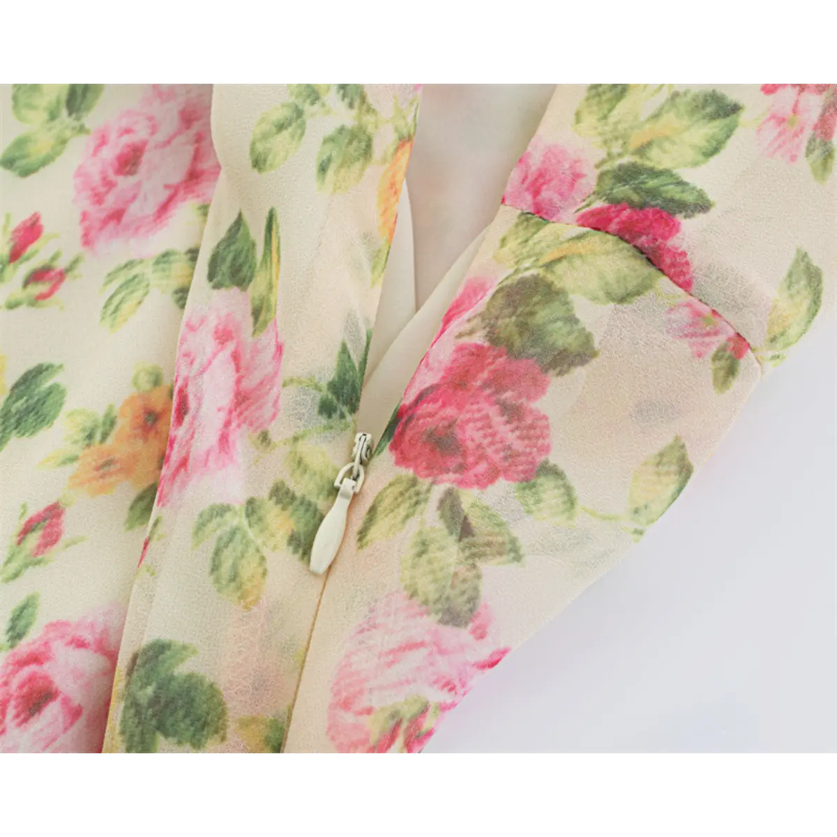 Close-up of the soft floral print and fabric texture on the cream maxi dress.