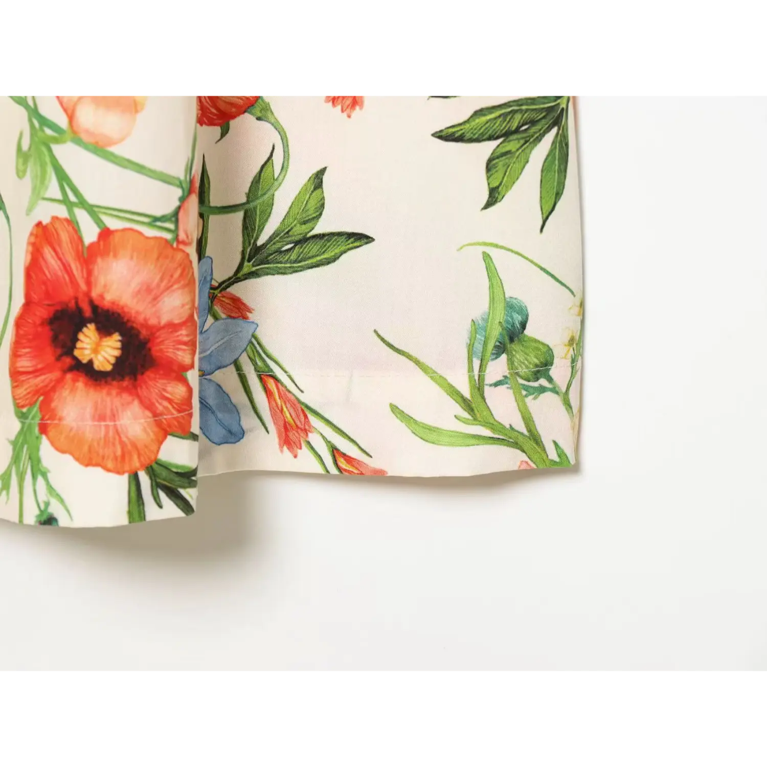 Close up of skirt fabric and watercolor floral print on cream shirt midi dress