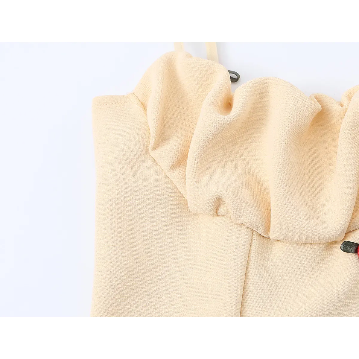 Close-up of the cami's ruffled neckline, showing the gathered fabric and floral embellishments