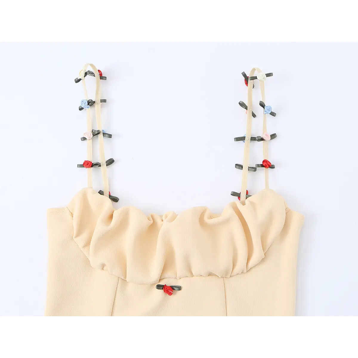 Close-up of the cami's ruffled neckline, showing the gathered fabric and floral embellishments