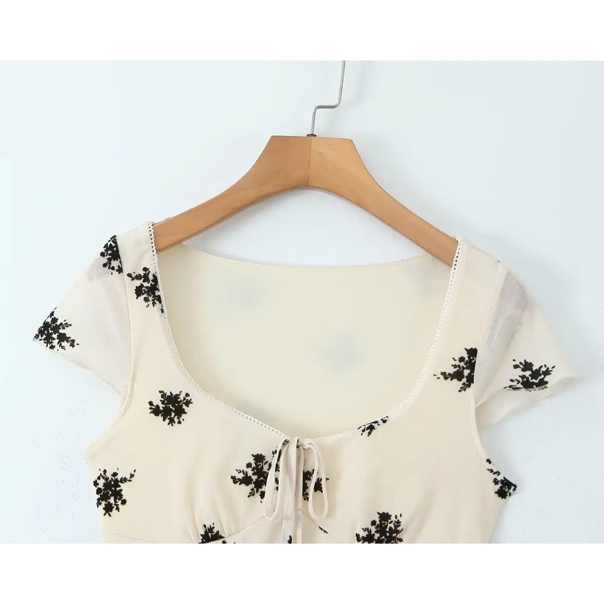 Full front shot of the cream floral mesh dress, displaying the square neck, tie detail, and short sleeves.