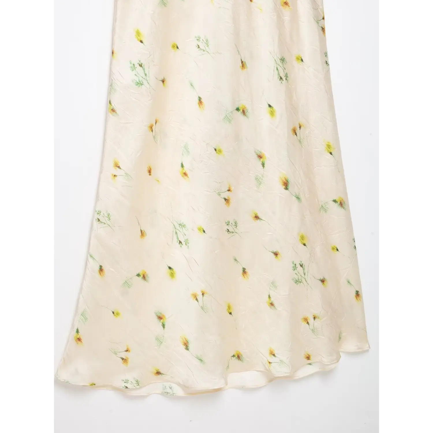 Macro shot wrinkled satin texture and yellow wildflower print on maxi skirt fabric