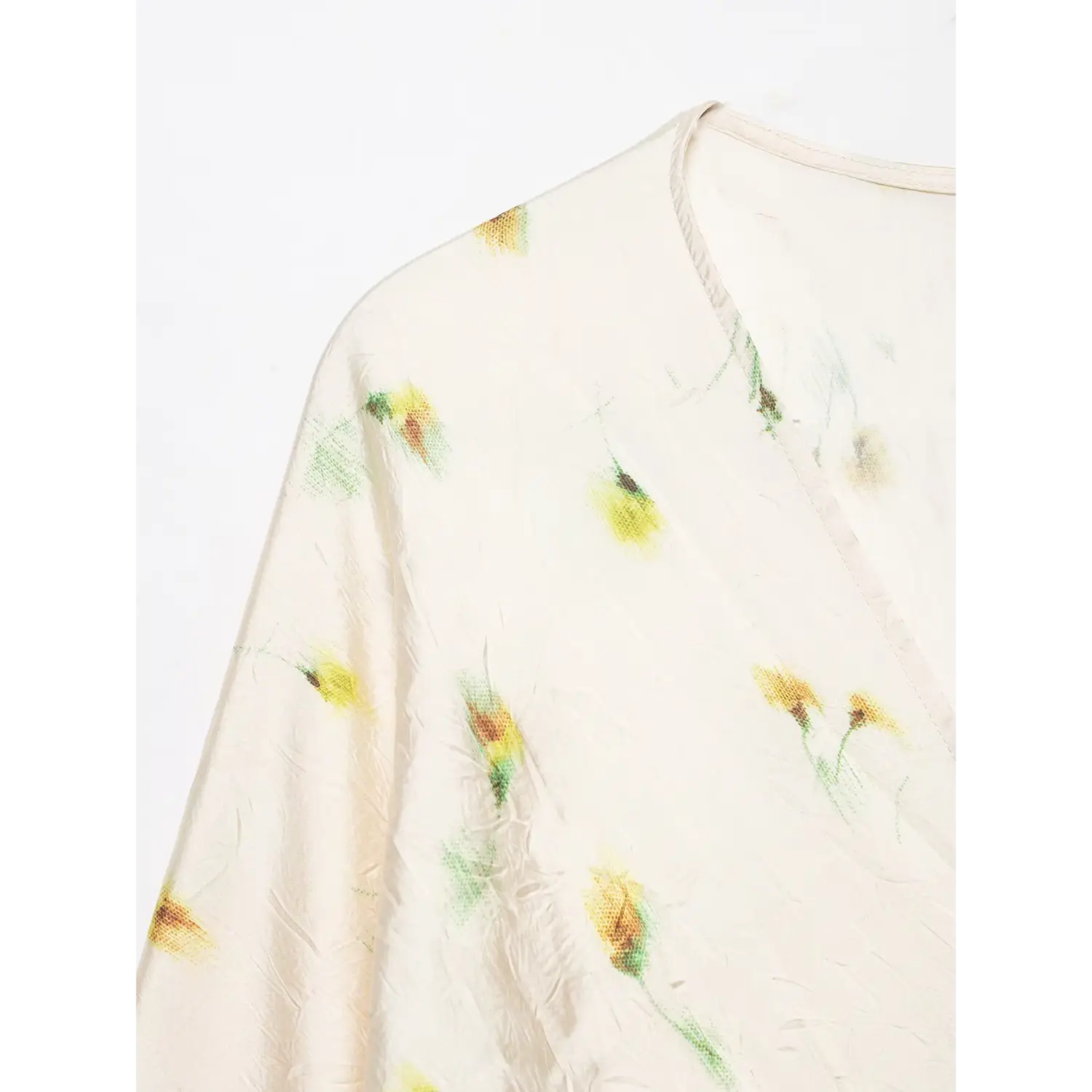 Close-up v neck and shoulder part of cream yellow floral maxi dress, textured wrinkled satin fabric with flower print