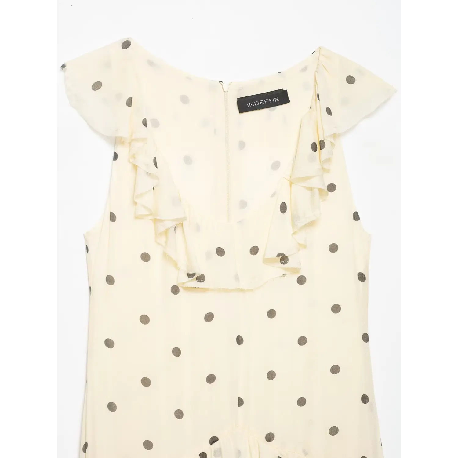 Close-up of the V-neck ruffle placket, back zipper and fabric label on polka dot chiffon dress
