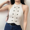 Outdoor model front wearing shot, cream halter top with black buttons and rope embroidery paired with denim jeans