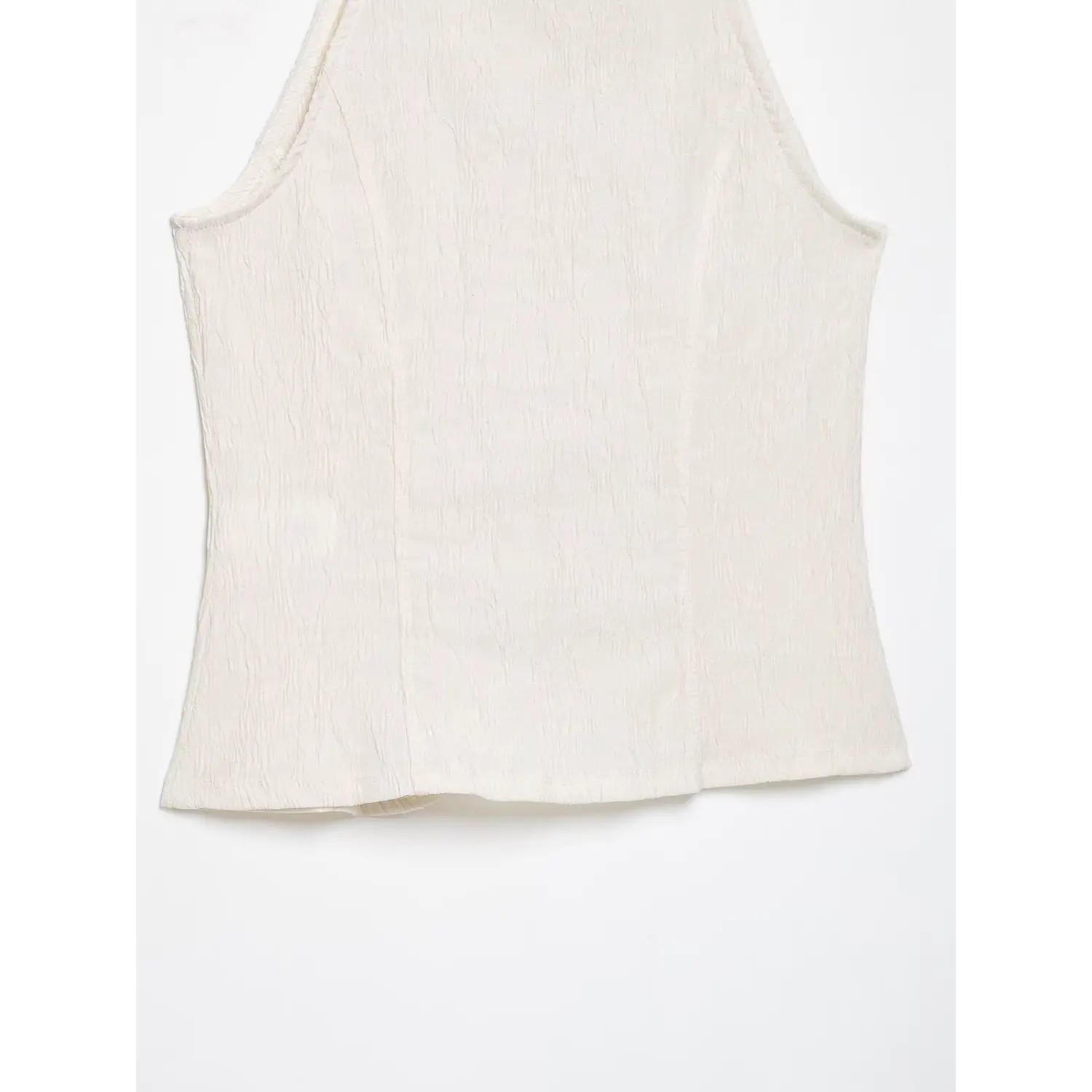 Close‑up back hem and vertical stitching seams of cream halter sleeveless top