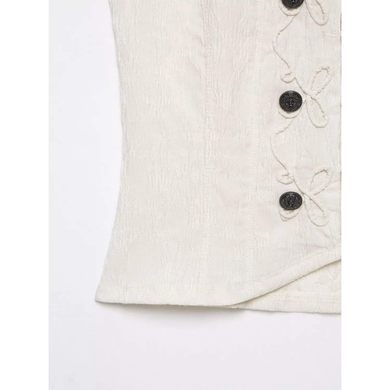 Close‑up view hem and side fabric texture of cream halter sleeveless top, curved hem stitching