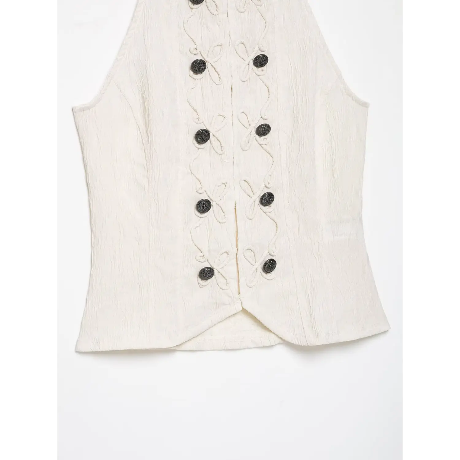 Close‑up lower front and curved hem cream halter sleeveless top, full button embroidery pattern