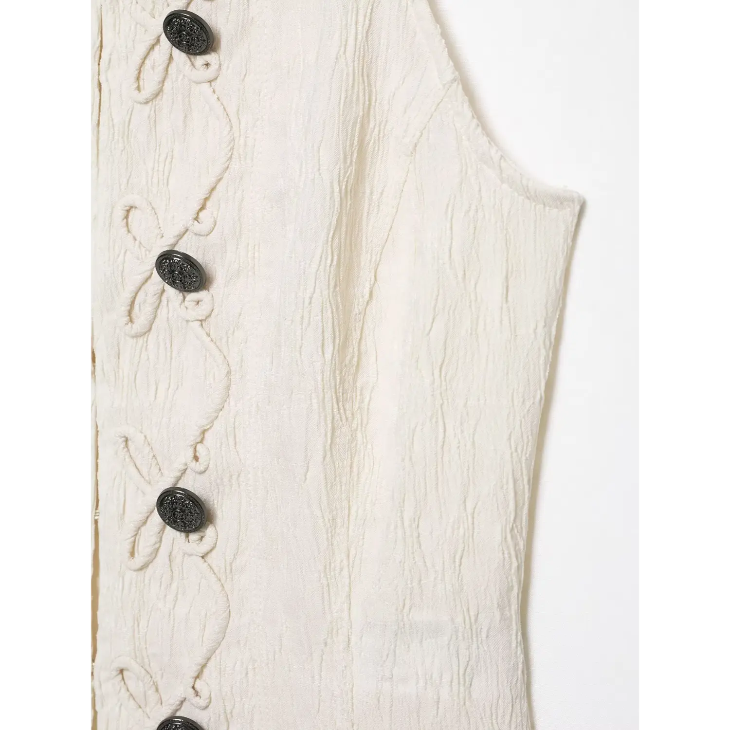 Close‑up side panel fabric texture and armhole stitching of cream halter sleeveless top