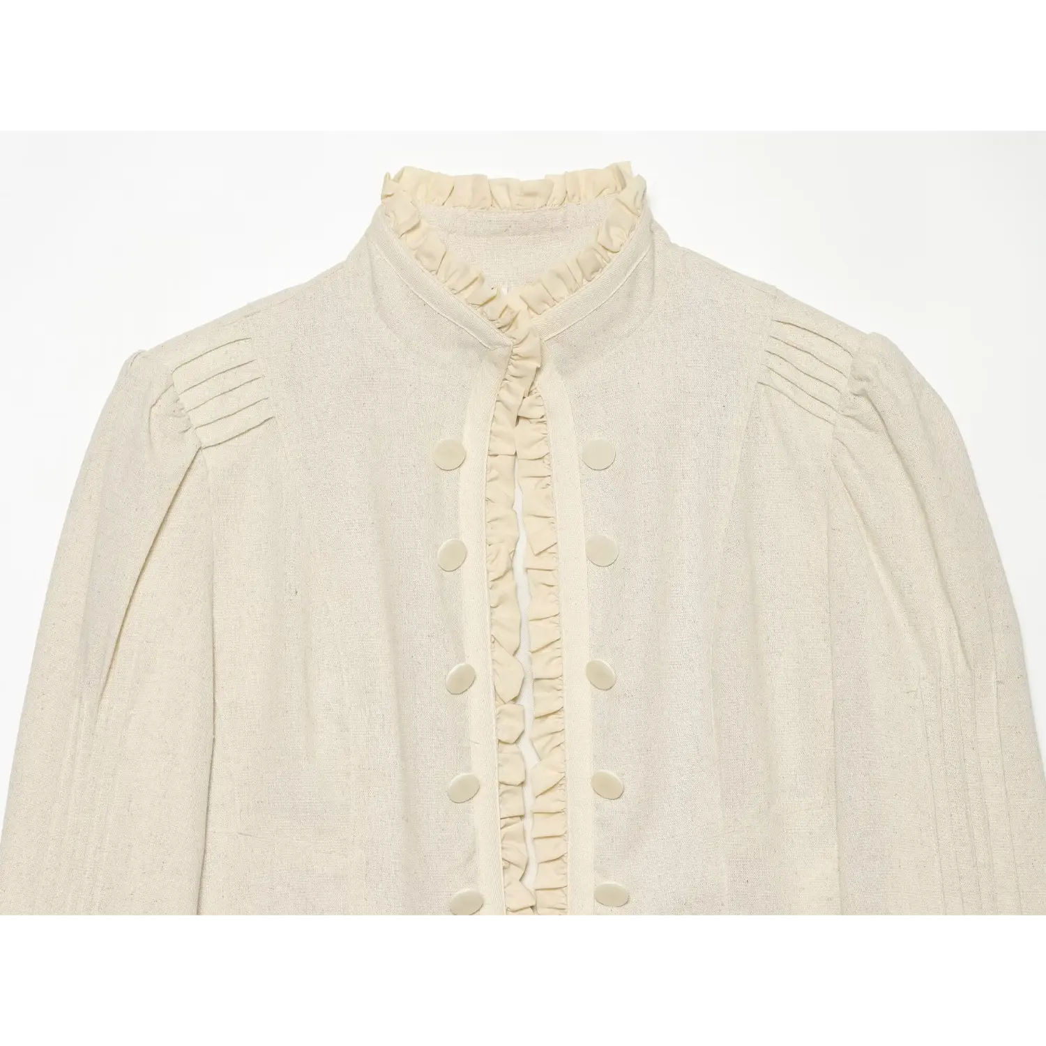 Close‑up of cream jacket ruffle stand collar and double‑row button placket, pleated shoulder detail, textured linen blend fabric