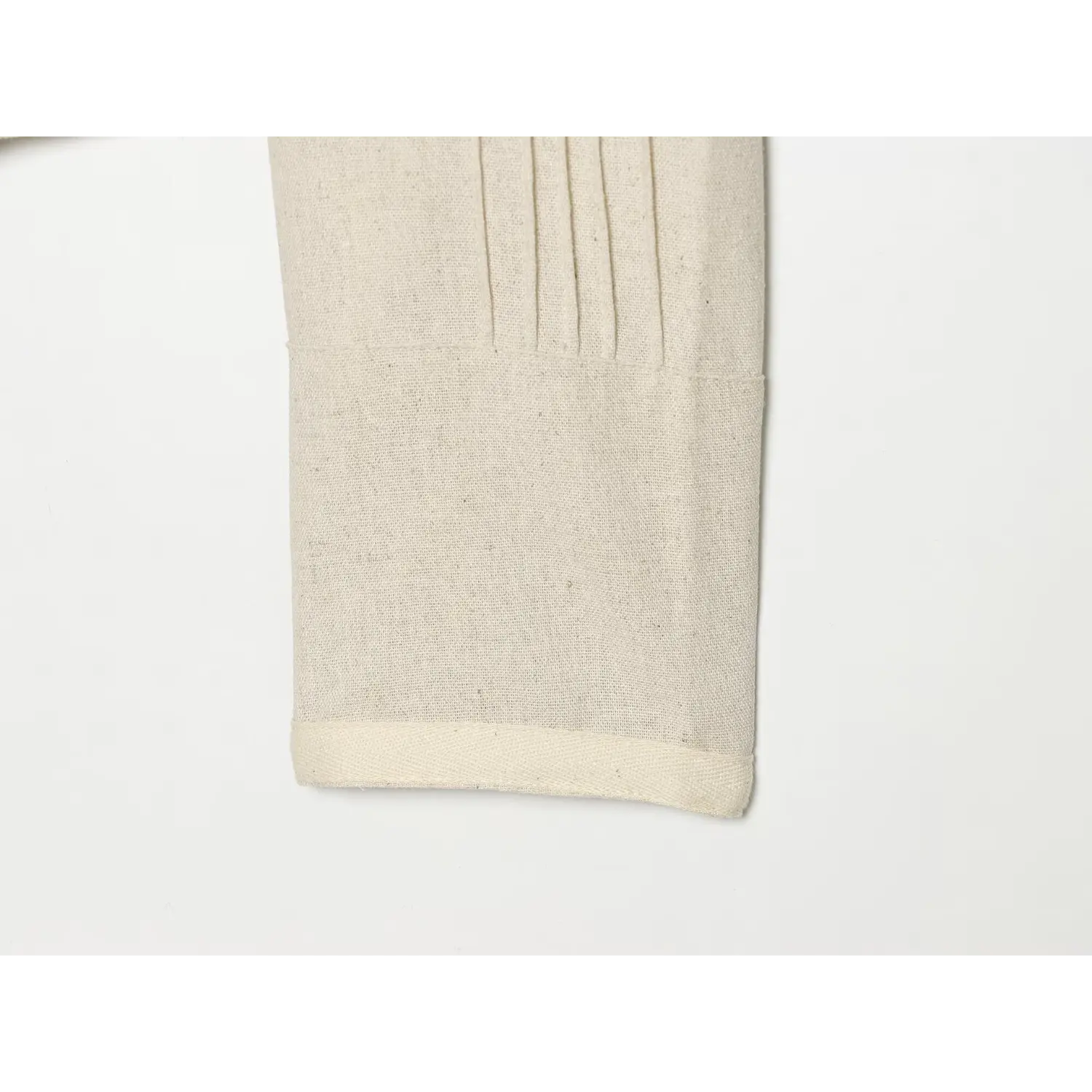 Close‑up of sleeve cuff with vertical pleat stitching on cream cropped jacket