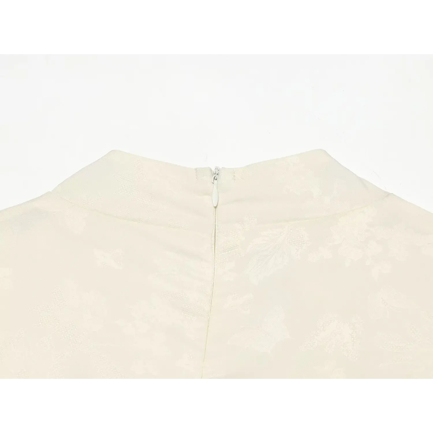Back stand neck invisible zipper close-up on cream subtle floral jacquard dress