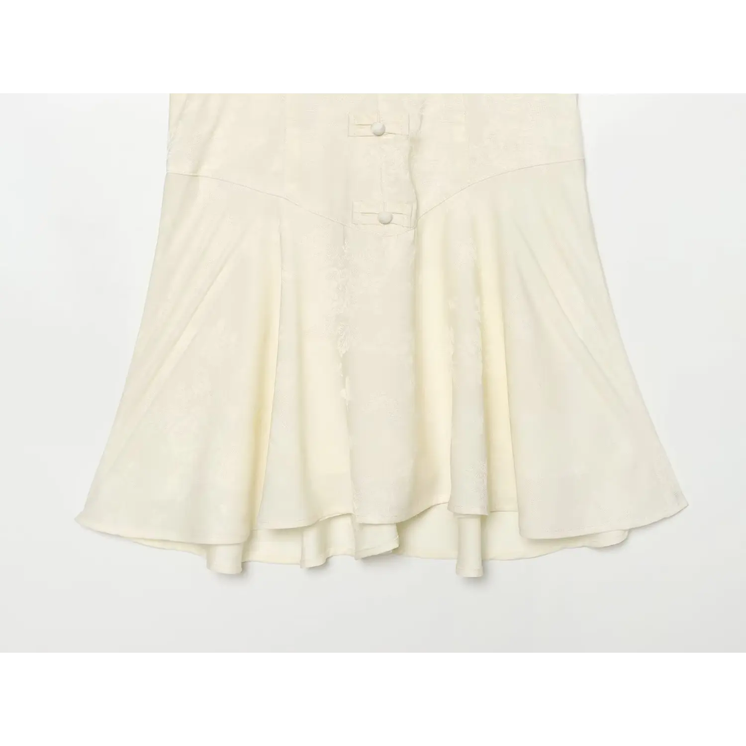 Flared pleated skirt hem close-up, lightweight cream jacquard mini dress with inner lining
