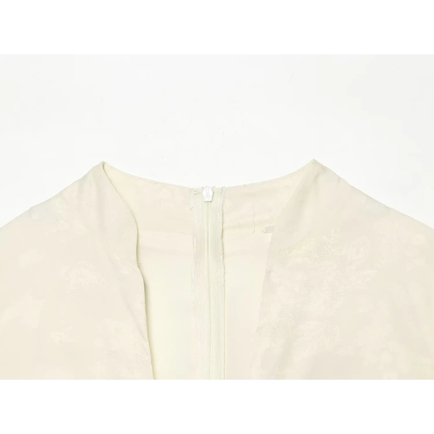 Close-up front v neck inner invisible zipper on cream butterfly jacquard fabric dress
