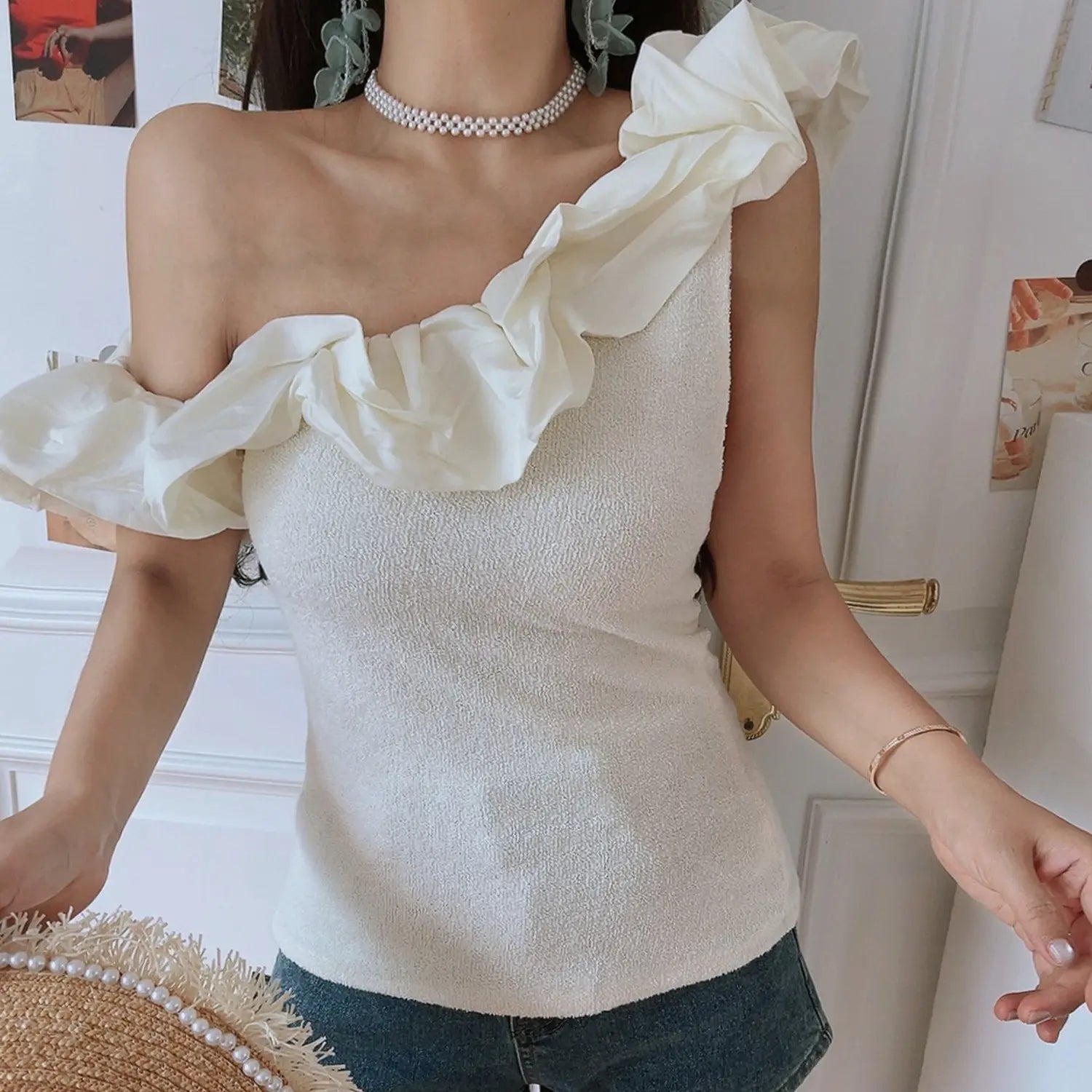 Cream textured knit one shoulder ruffle crop top, big chiffon ruffle fitted cut, side front indoor model shot with denim
