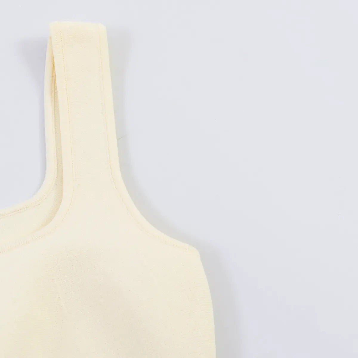 Back view detail of the cream knit tank top, showing the fitted silhouette
