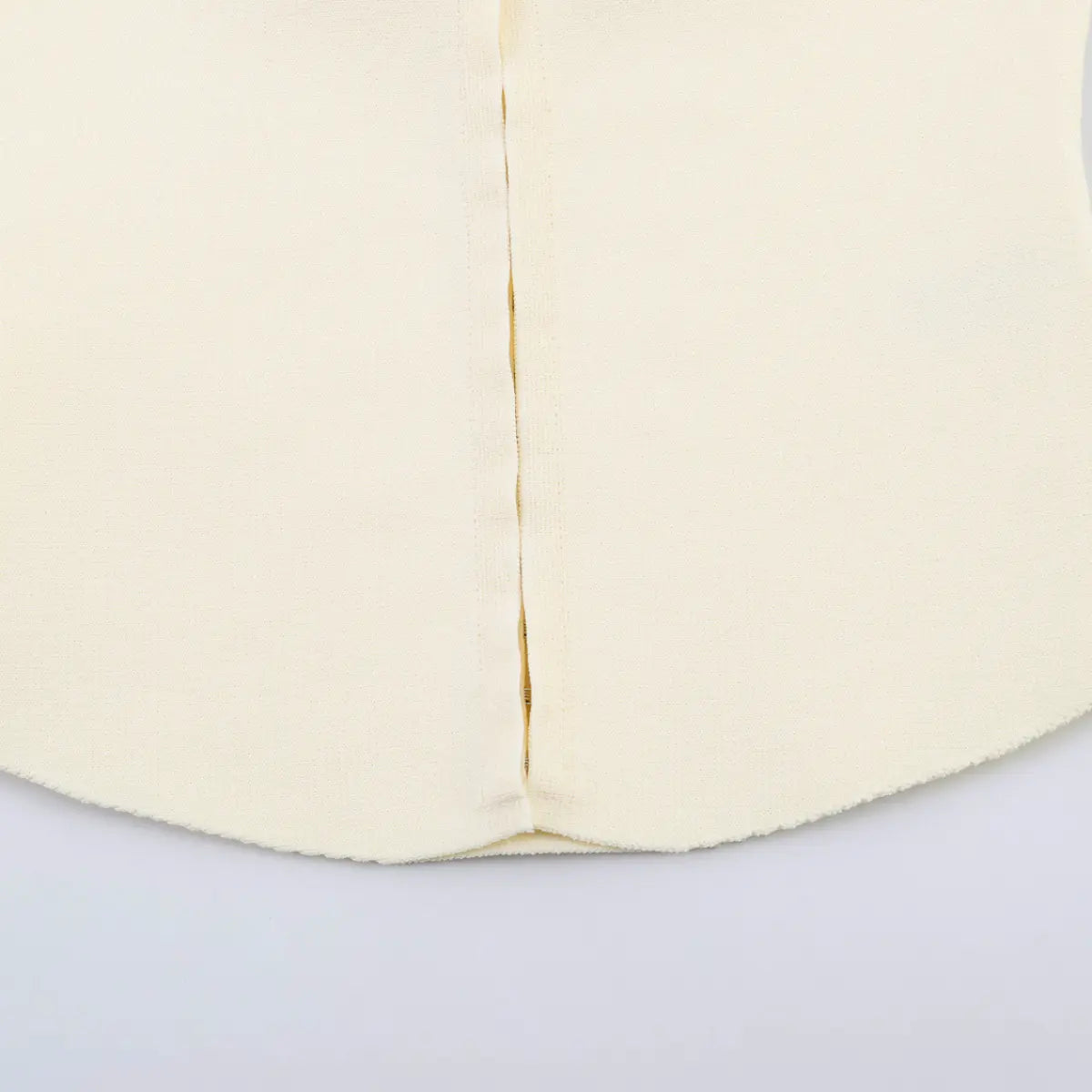 Close-up of the hook-and-eye front closure on the cream knit tank top