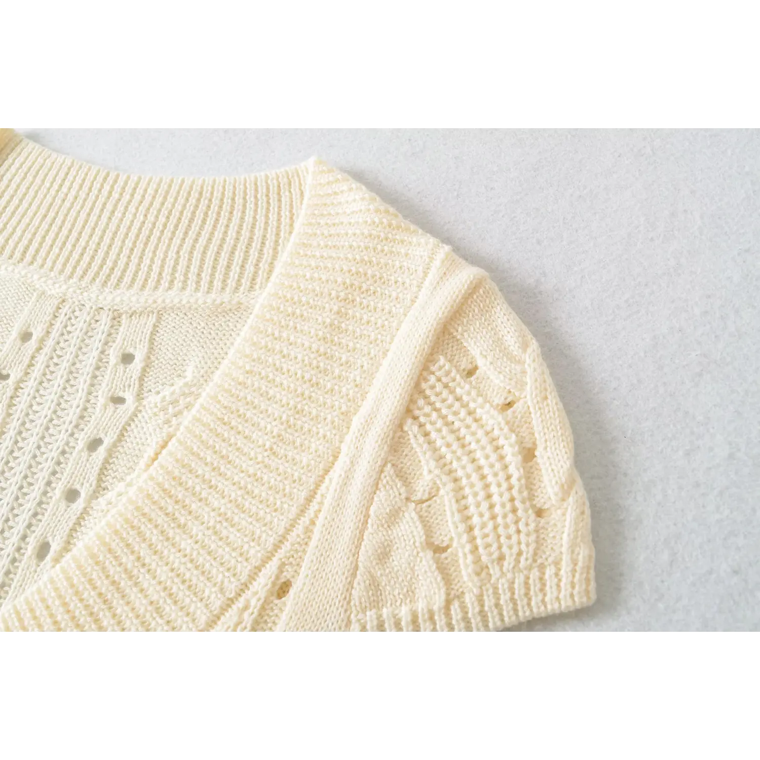 Close up of ribbed crew shoulder cap sleeve hollow cable knit cream women short sleeve knit top